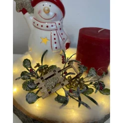 Weihnachtsdeko auf Baumscheibe mit Schneemann und Kerze