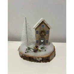 Weihnachtsdeko auf einer Baumscheibe mit einem Häuschen