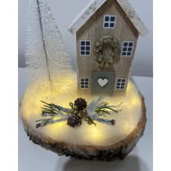 Weihnachtsdeko auf einer Baumscheibe mit einem Häuschen