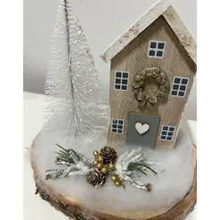 Weihnachtsdeko auf einer Baumscheibe mit einem Häuschen