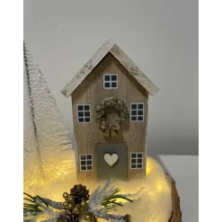 Weihnachtsdeko auf einer Baumscheibe mit einem Häuschen