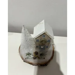 Weihnachtsdeko auf einer Baumscheibe mit einem Häuschen