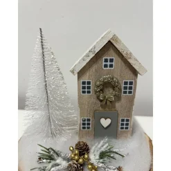 Weihnachtsdeko auf einer Baumscheibe mit einem Häuschen