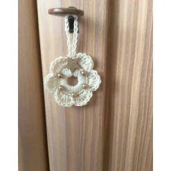 Weihnachts-Häkelkränzchen in beige mit braunen Perlen und Holzsternchen verziert