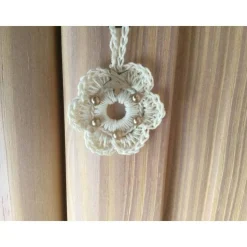 Weihnachts-Häkelkränzchen in beige mit braunen Perlen und Holzsternchen verziert