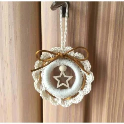 Weihnachts-Häkelkränzchen in beige mit Satinkordel und einem Holzstern verziert