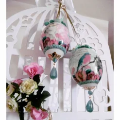 Wunderschönes dekoriertes Ei mit Schmuckstein und Dekoblüten