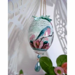 Wunderschönes dekoriertes Ei mit Schmuckstein und Dekoblüten