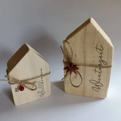 Zwei zuckersüße Holzhäuser mit „Willkommen Winterzeit“